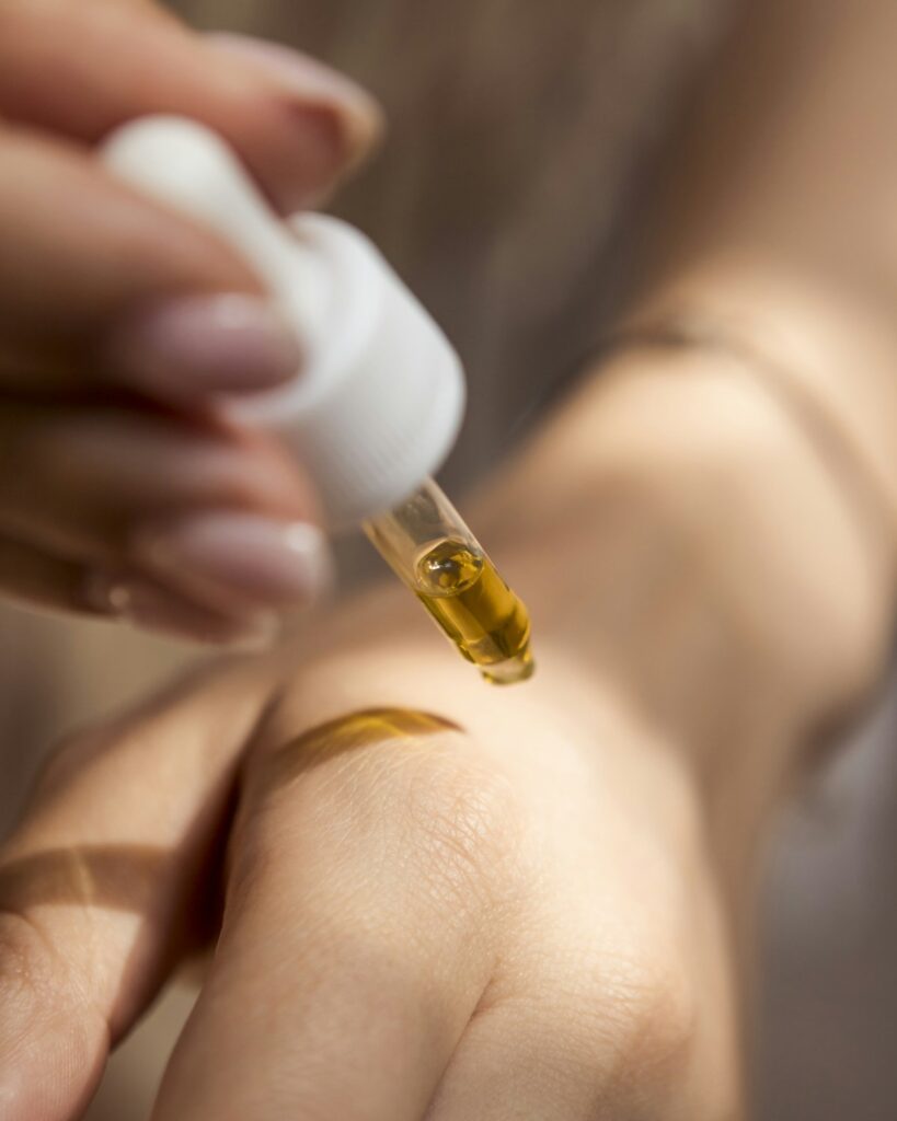 Person applying CBD oil from dropper, hemp tincture use