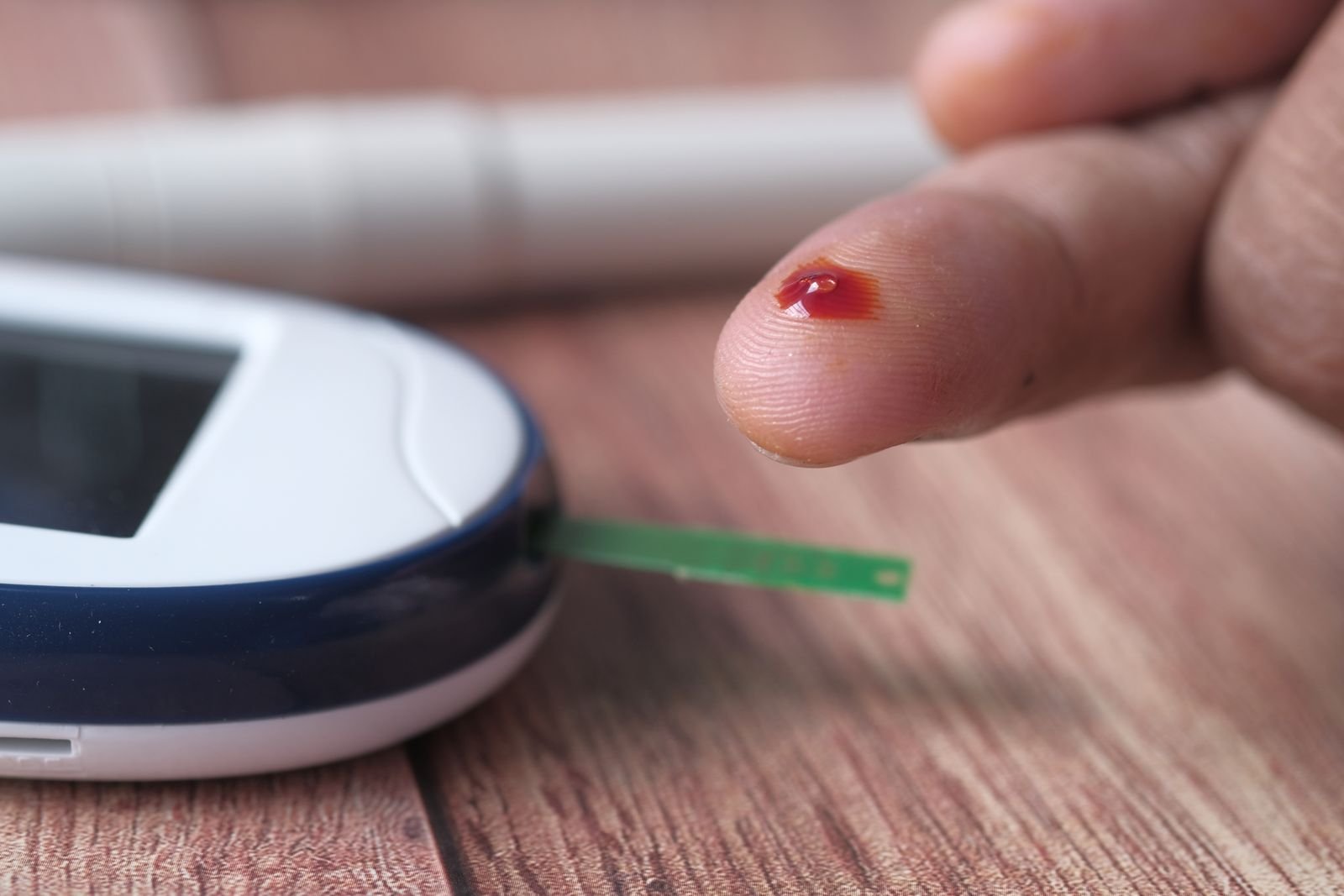Close-up of a blood glucose monitor test strip reading
