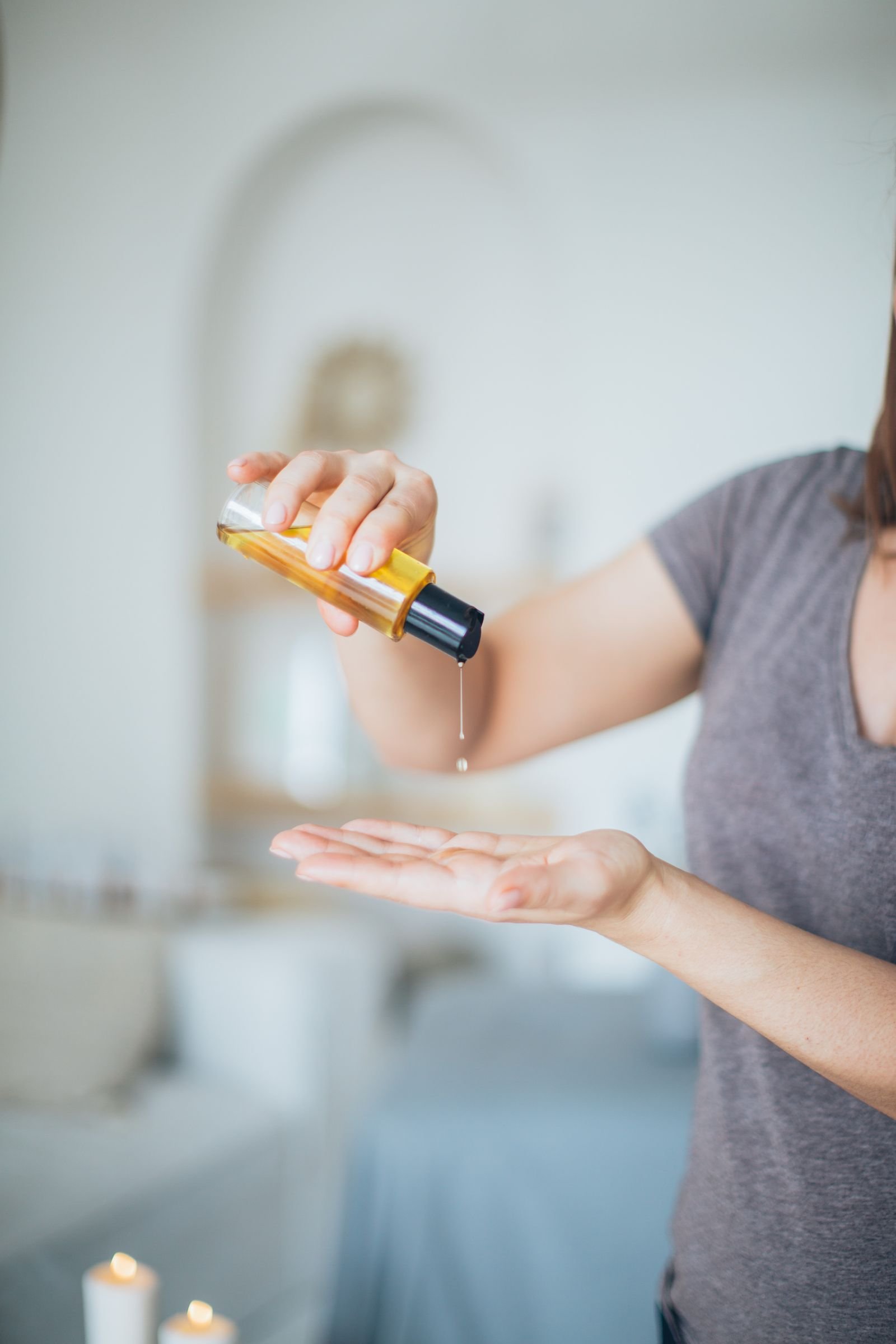 Hand pouring CBD massage oil for a therapeutic massage