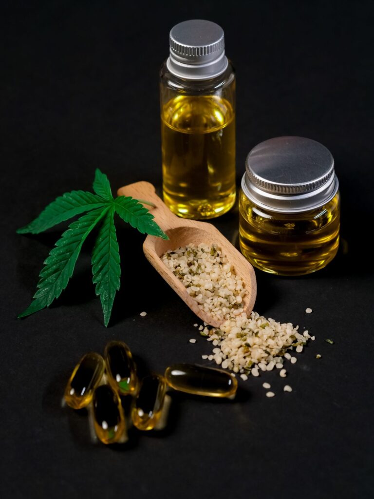 CBD oil, capsules, and hemp seeds arranged together showing hemp compounds
