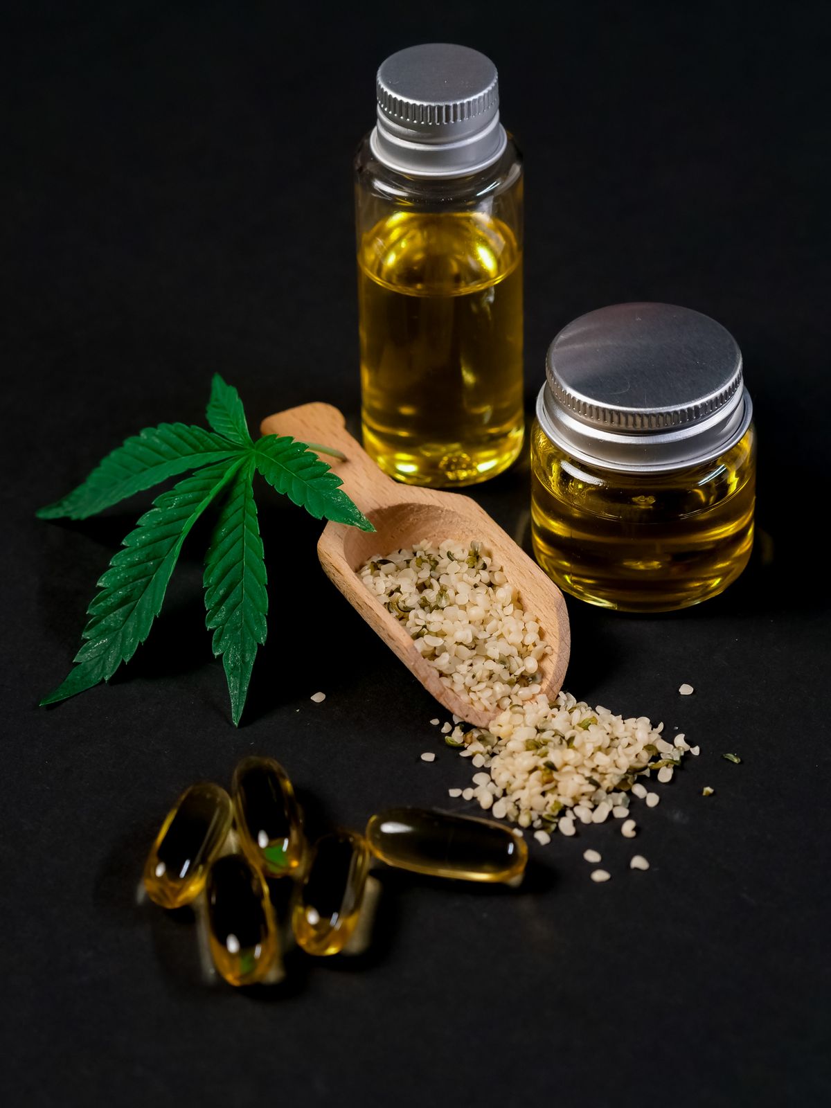 CBD oil, capsules, and hemp seeds arranged together showing hemp compounds