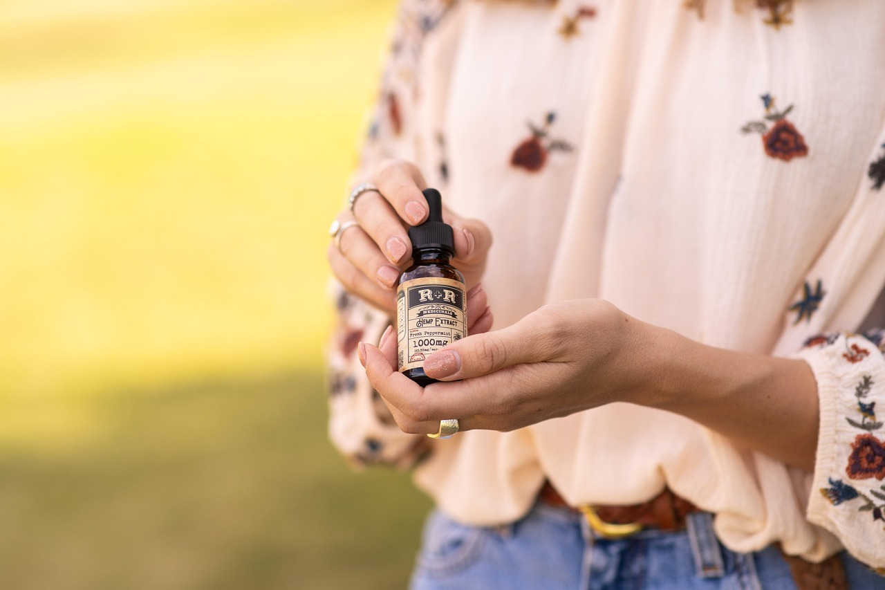 Hand holding a dropper bottle of CBD oil tincture