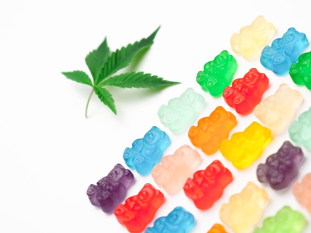 Assorted CBD hemp gummies with a cannabis leaf on a white surface