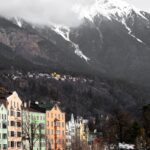 Innsbruck Austria with colorful buildings below snow capped Alps
