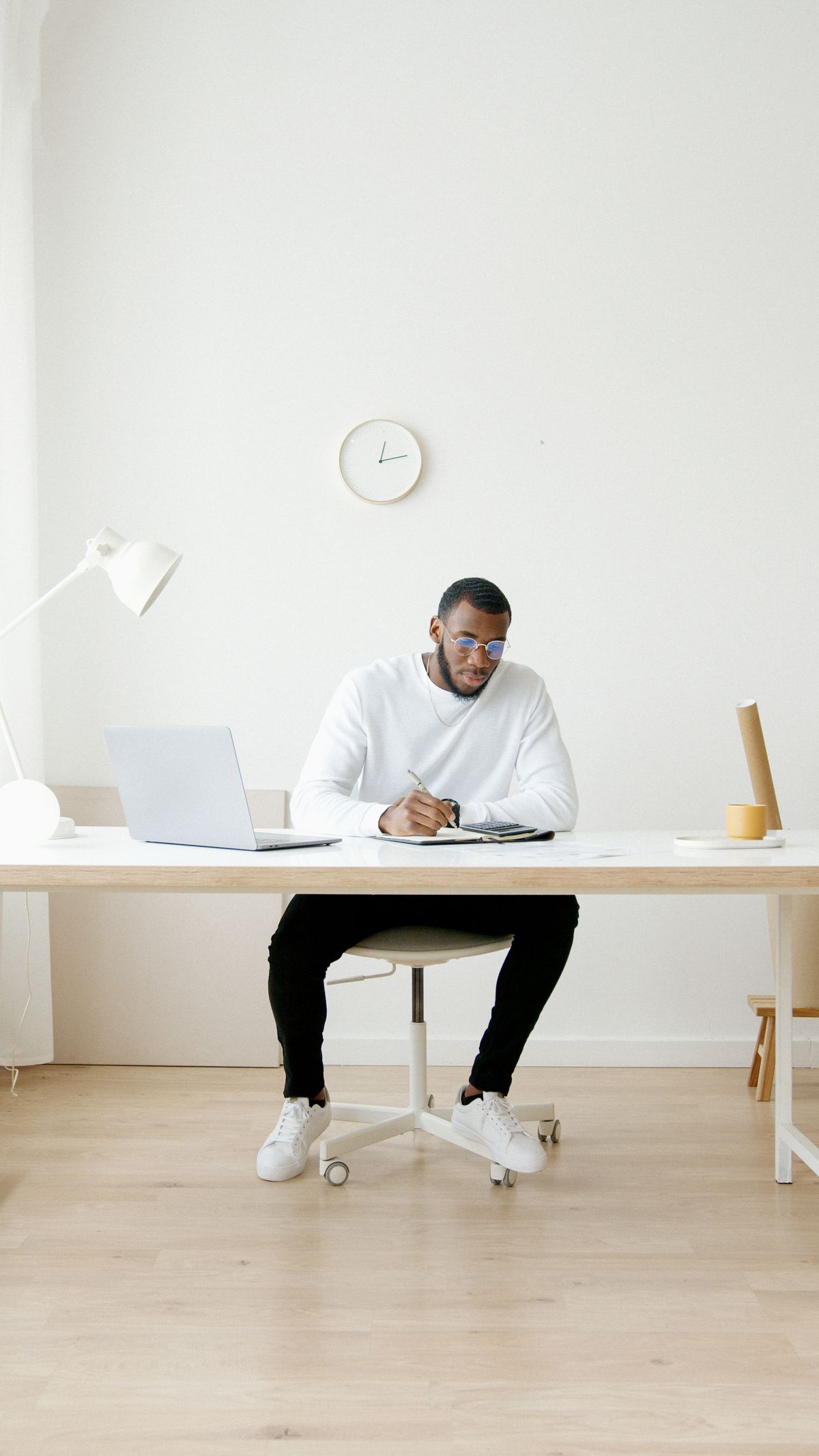 Man focused and writing notes at an organized home desk