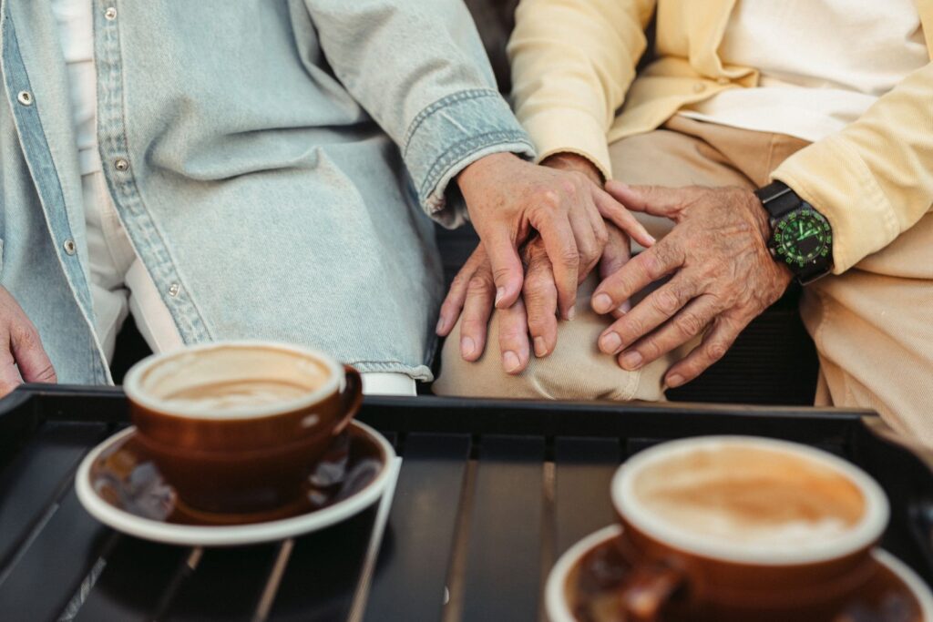 Mature couple holding hands over coffee