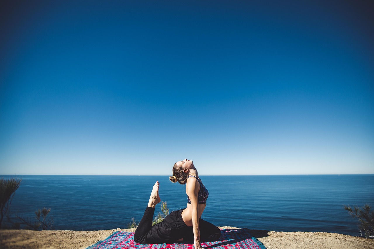 Woman stretching gently outdoors by the sea for mobility and wellness