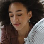 Woman cooling herself with a fan for hot flash relief during menopause