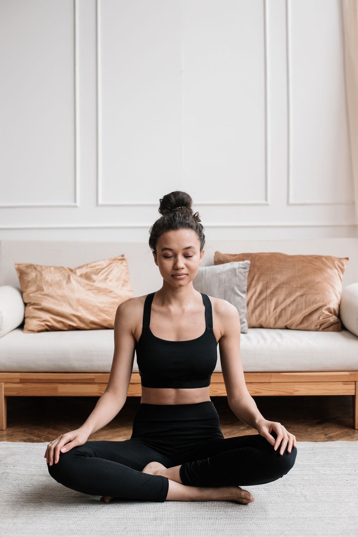 Woman sitting calmly in meditation at home for stress relief