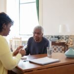 Caregiver going over medication with an older man at home, discussing the Medicare CBD pilot program