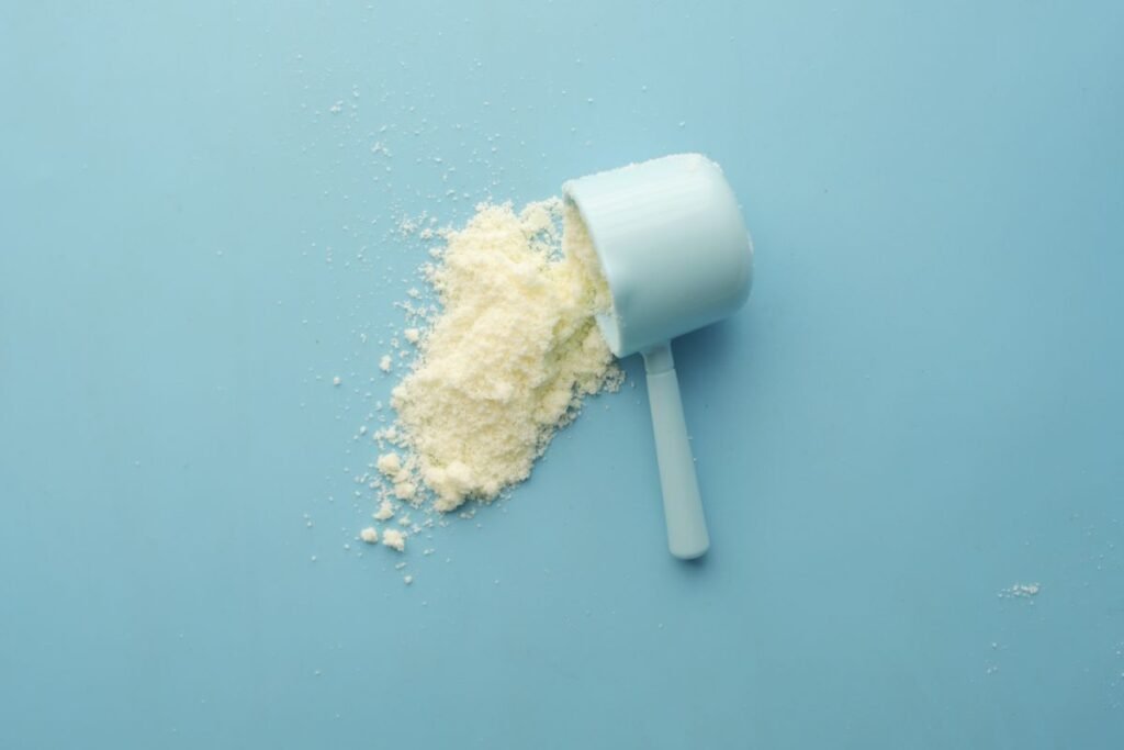 White crystalline powder spilling from a scoop, representing CBD isolate