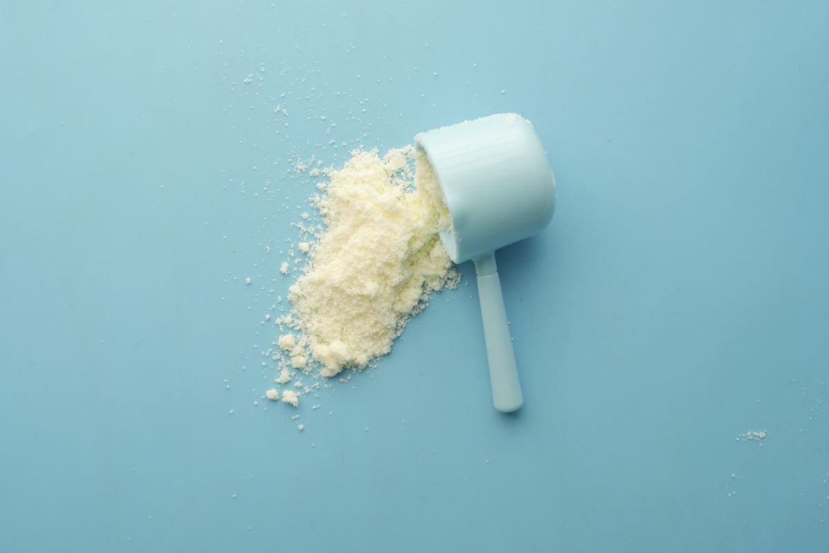 White crystalline CBD isolate powder spilling from a scoop