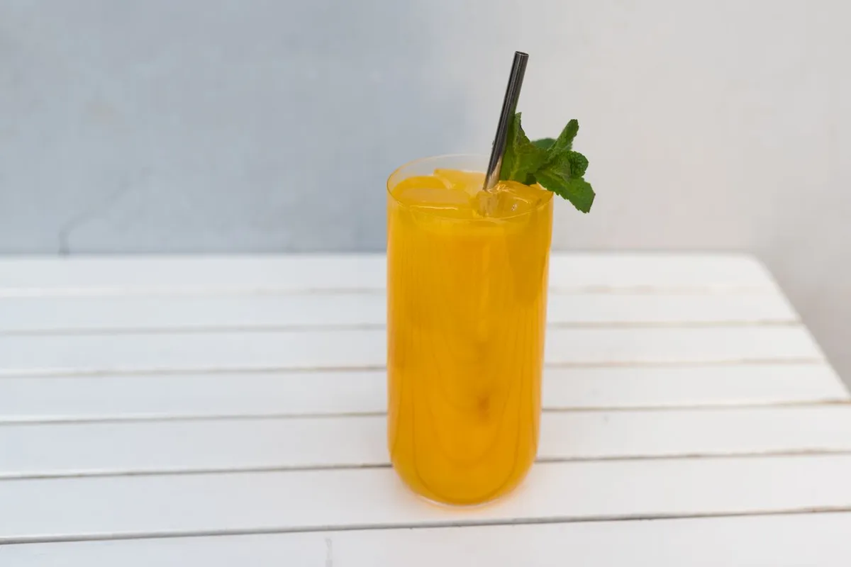 Tall glass of a prepared non-alcoholic drink with mint, the kind a THC mixer is added to