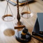Scales of justice and a gavel on a wooden desk representing THC legal limits