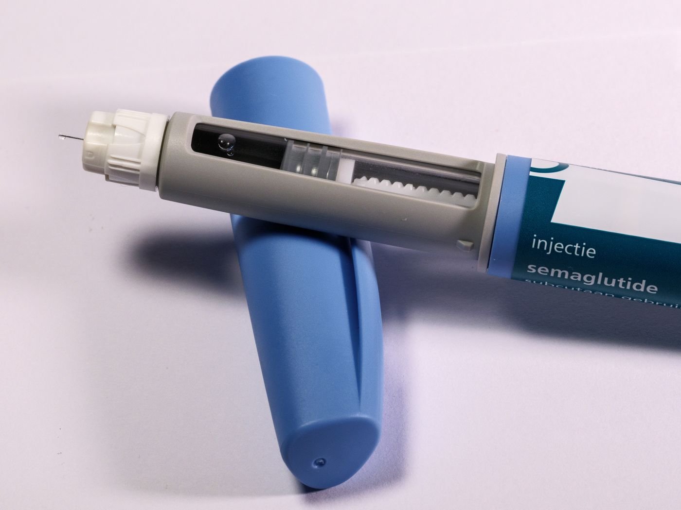 Semaglutide injection pen on a light surface, the drug sold as Ozempic and Wegovy